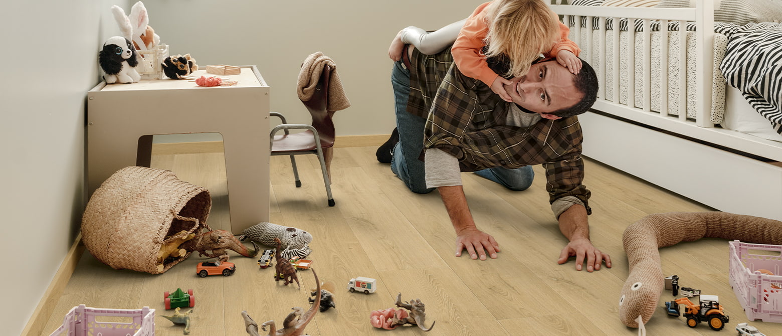 padre jugando con su hija en una habitación llena de juguetes